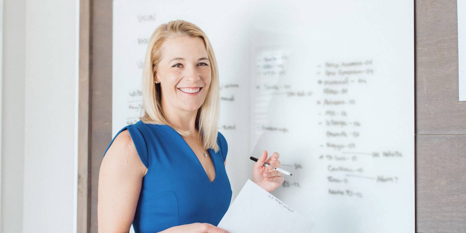 Annaliese Peterson in her office standing at whiteboard.