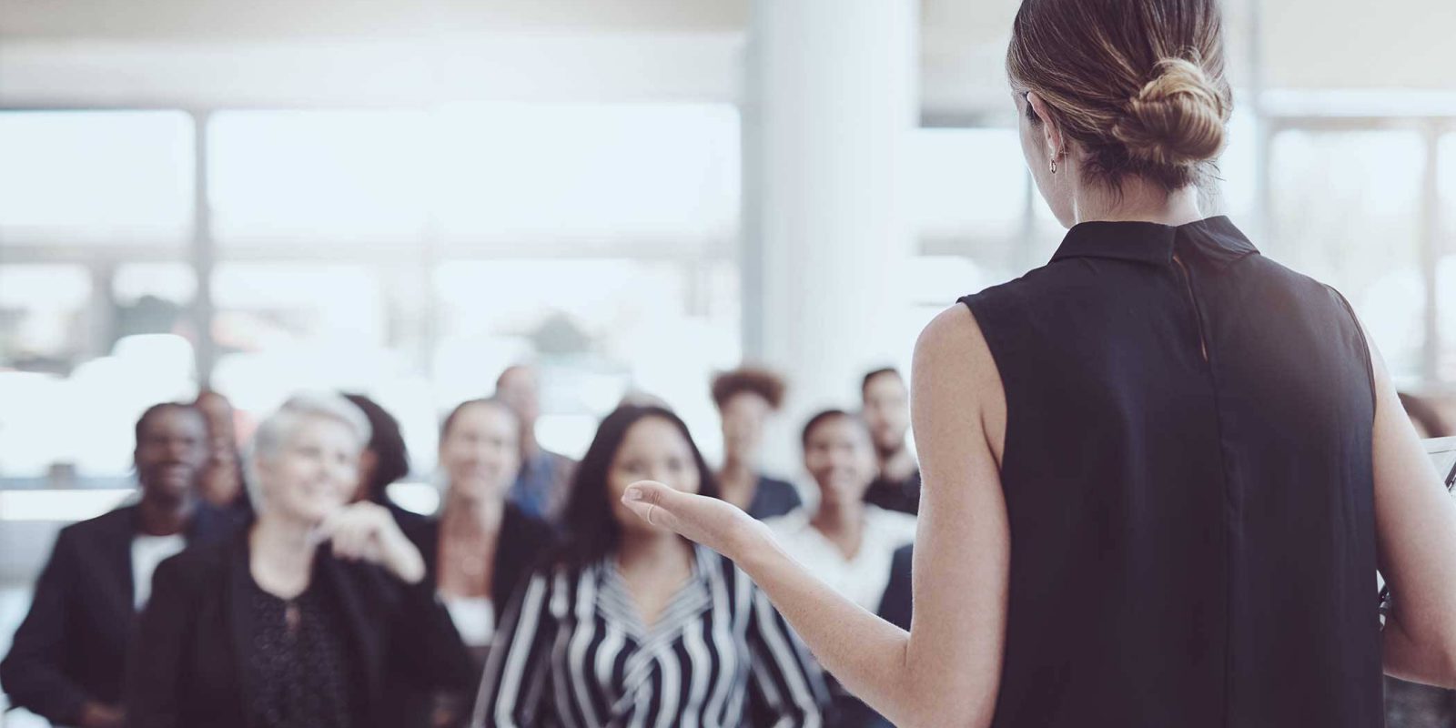 Women standing in front of crowd presenting.